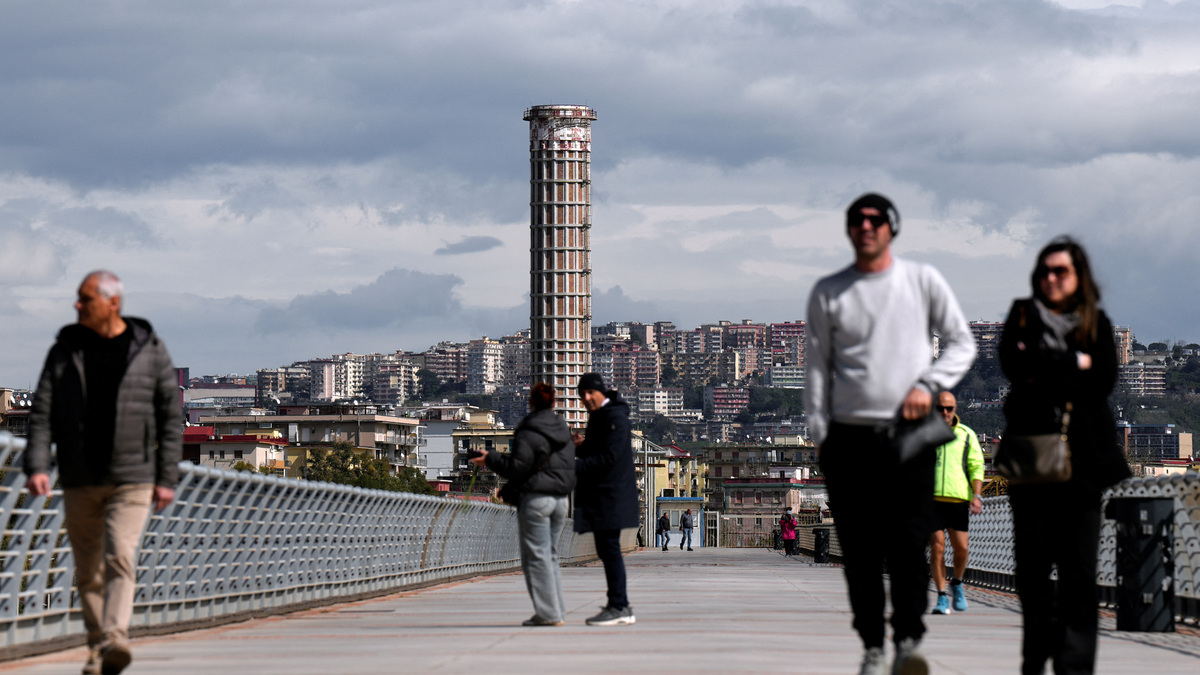 People walk along the pedestrian promenade of the Pontile Nord in Bagnoli, Naples, Italy, March 17, 2026. REUTERS/Matteo Ciambelli