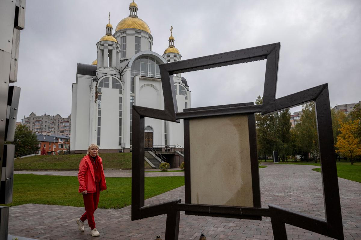 Tetiana Popovych, who said her son, Vladyslav, was shot, captured and beaten by Russian soldiers in 2022, visits a memorial site for victims of the month-long occupation of Bucha, outside Kyiv, Ukraine, October 9, 2025. REUTERS/Thomas Peter