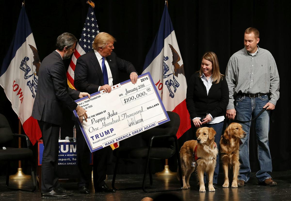  In this Jan. 30, 2016 photo, Donald Trump stages a check presentation with an enlarged copy of a $100,000 contribution from the Donald J. Trump Foundation to Puppy Jake, a veteran's charity, at a campaign event in Davenport, Iowa. AP Photo/Paul Sancya 
