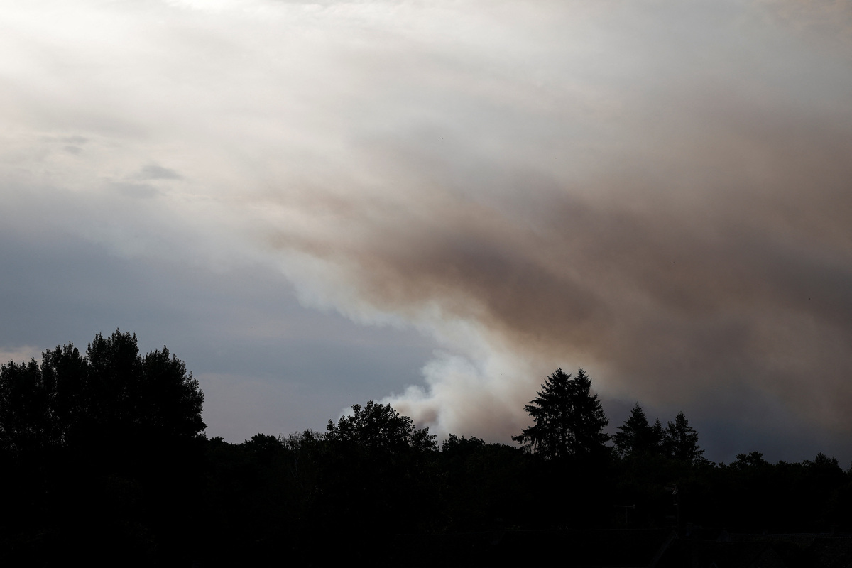 Smoke rises from a wildfire, as French firefighters battle the blaze in the Fontainebleau forest in in Noisy-sur-Ecole near Paris, amid a heatwave affecting a large part of the country, France, July 13, 2026. REUTERS/Benoit Tessier