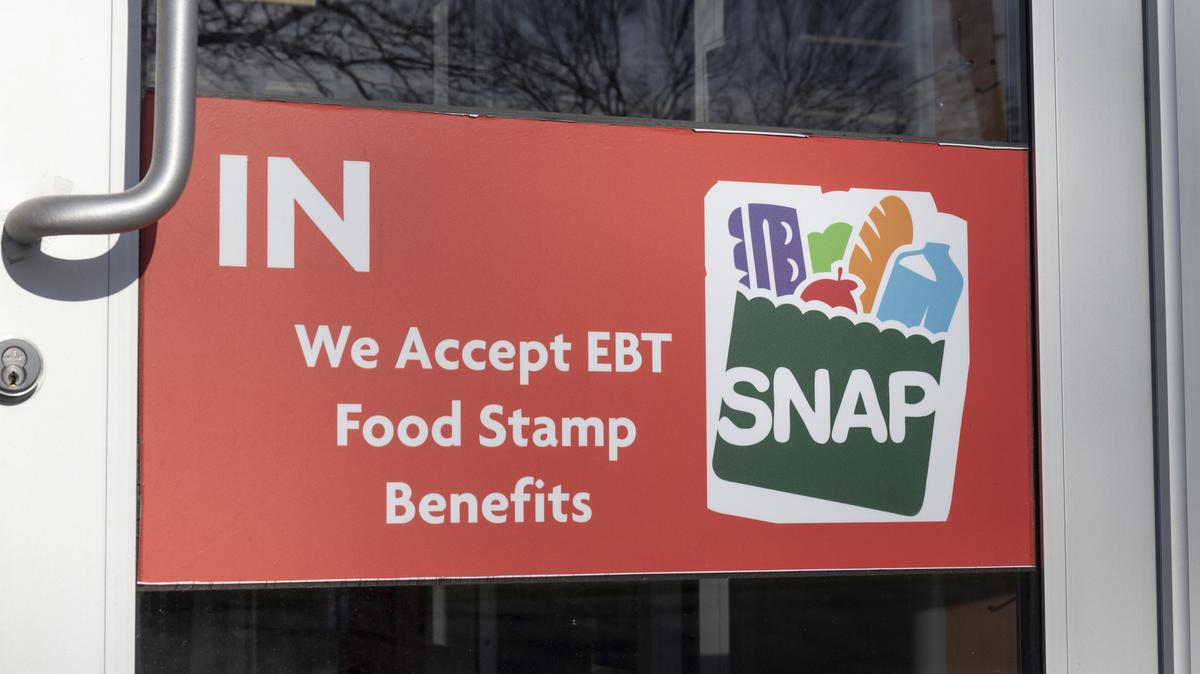 SNAP and EBT Accepted here sign. SNAP and Food Stamps provide nutrition benefits to supplement the budgets of disadvantaged families.. Stock image/file photo: A SNAP sign in a retailer window.
