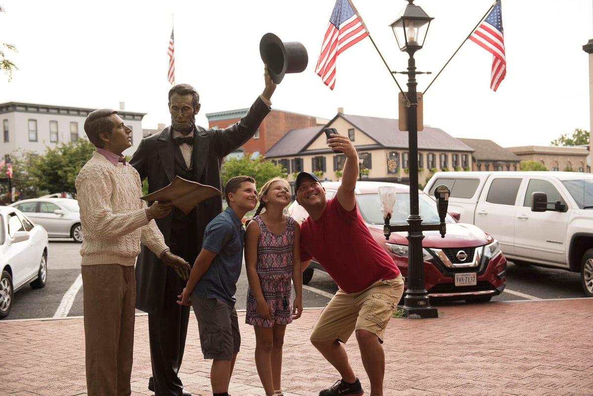 Visitors take a selfie with a statue of Abraham Lincoln in Gettysburg, Pennsylvania, the site of a crucial Civil War battle and Lincoln's famous address to a nation torn apart.