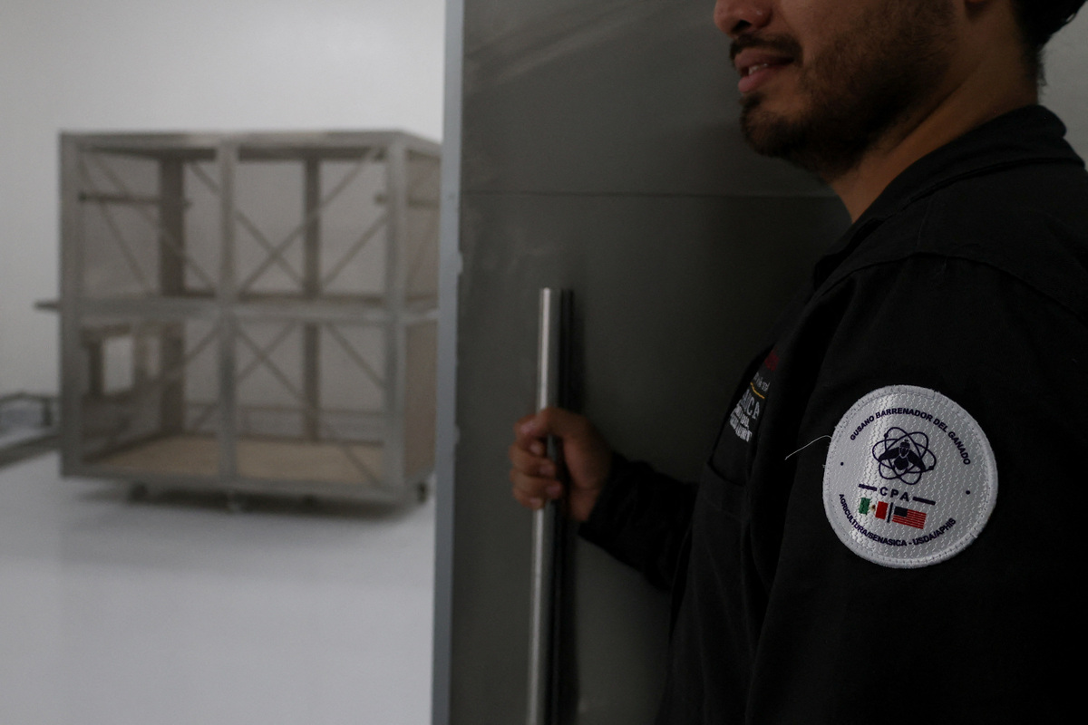 A worker holds the door of a fly colony area during a media tour following the opening of a sterile fly production plant, a key step to contain the cross-border spread of the New World screwworm and its impact on cattle trade, in Metapa de Domínguez, Chiapas, Mexico, June 27, 2026. REUTERS/Damian Sanchez