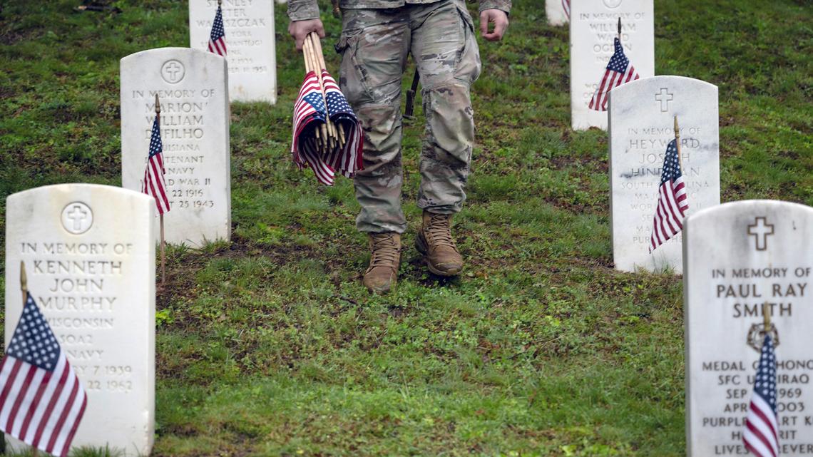 Service members place U.S. flags at Arlington National Cemetery during the Annual Flags-In Ceremony in Arlington, Virginia, on May 22, 2025, as part of the Memorial Day remembrances on the Monday holiday. (Brendan Smialowski/AFP/Getty Images/TNS)