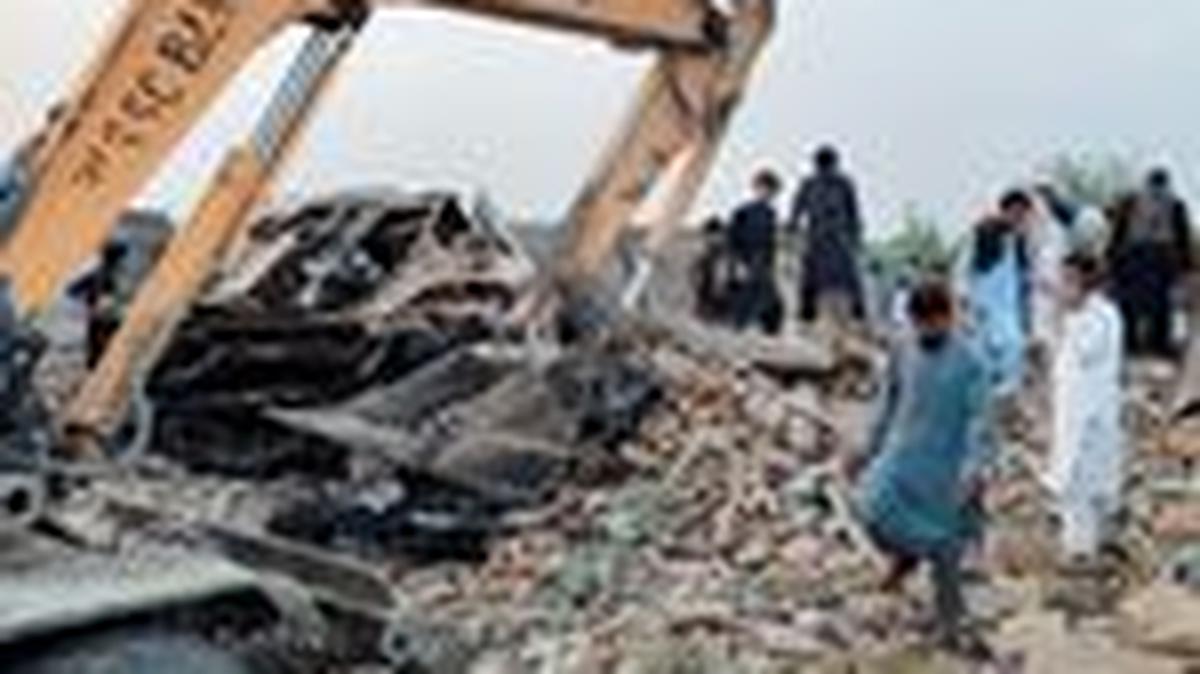 Residents gather on the rubble of a damaged police post after a car bombing in Bannu, Khyber Pakhtunkhwa province, Pakistan May 10, 2026. Picture taken with a mobile phone. REUTERS/Ehsan Khattak