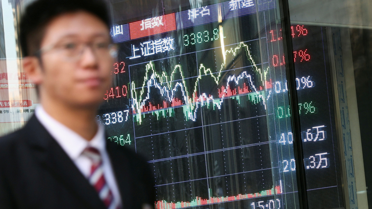 A man walks past a brokerage house with a display board showing the Shanghai Composite Index and other stock information, in Beijing, China November 6, 2024. REUTERS/Florence Lo