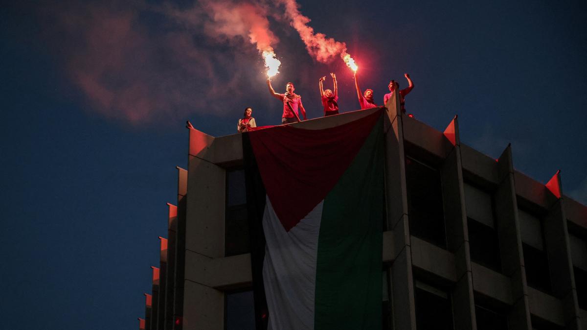 Protesters who hung a huge Palestinian flag at a building facing the Israeli embassy, lit flares during a protest over the interception of the Gaza aid flotilla, in Athens, Greece, May 21, 2026. REUTERS/Louisa Gouliamaki