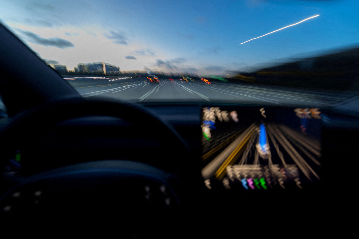 FILE PHOTO: A display of a Tesla Model 3 using Full Self-Driving Supervised on a highway in San Diego, California, U.S., April 15, 2026. Picture taken with a long exposure. REUTERS/Mike Blake/File Photo