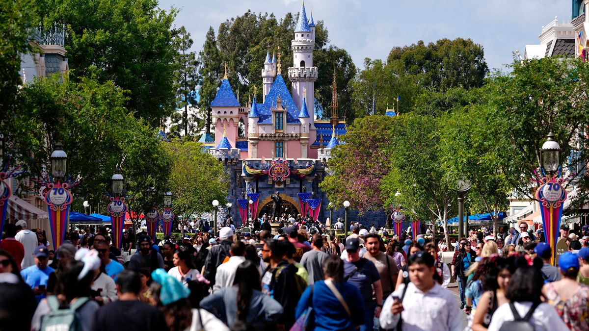 Parkgoers walk along Main Street with the iconic Sleeping Beauty Castle in the background at Disneyland Park in Anaheim, Calif., on May 13, 2025.