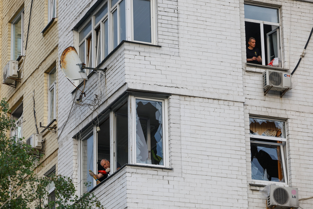 Residents remove pieces of glass from broken windows of their apartments, which were damaged during Russian missile strikes, amid Russia's attack on Ukraine, in Kyiv, Ukraine July 11, 2026. REUTERS/Valentyn Ogirenko