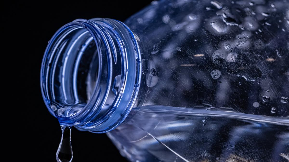 This illustration photograph taken on January 9, 2024, shows a view of a plastic bottle of water with a drop flowing out of it in Paris. Bottled water is up to a hundred times worse than previously thought when it comes to the number of tiny plastic bits it contains, a new study in the Proceedings of the National Academy of Sciences said on January 8, 2024. (Photo by JOEL SAGET / AFP via Getty Images)