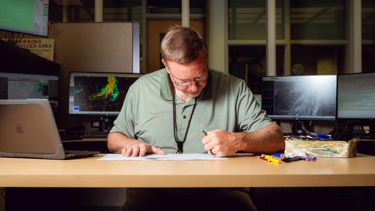 John Hart works on a surface weather map at the National Weather Service’s Storm Prediction Center in Norman, Okla., as a day of stormy weather threatens the Midwest on April 27, 2026. With a battery of modern technology at their fingertips, meteorologists often turn first to making paper maps.