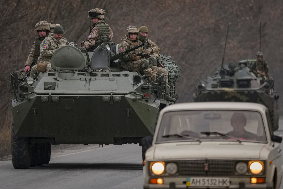 Militares ucranianos se trasladan en vehículos blindados por una carretera en la región de Donetsk, en el este de Ucrania, el jueves 24 de febrero de 2022. (AP Foto/Vadim Ghirda)