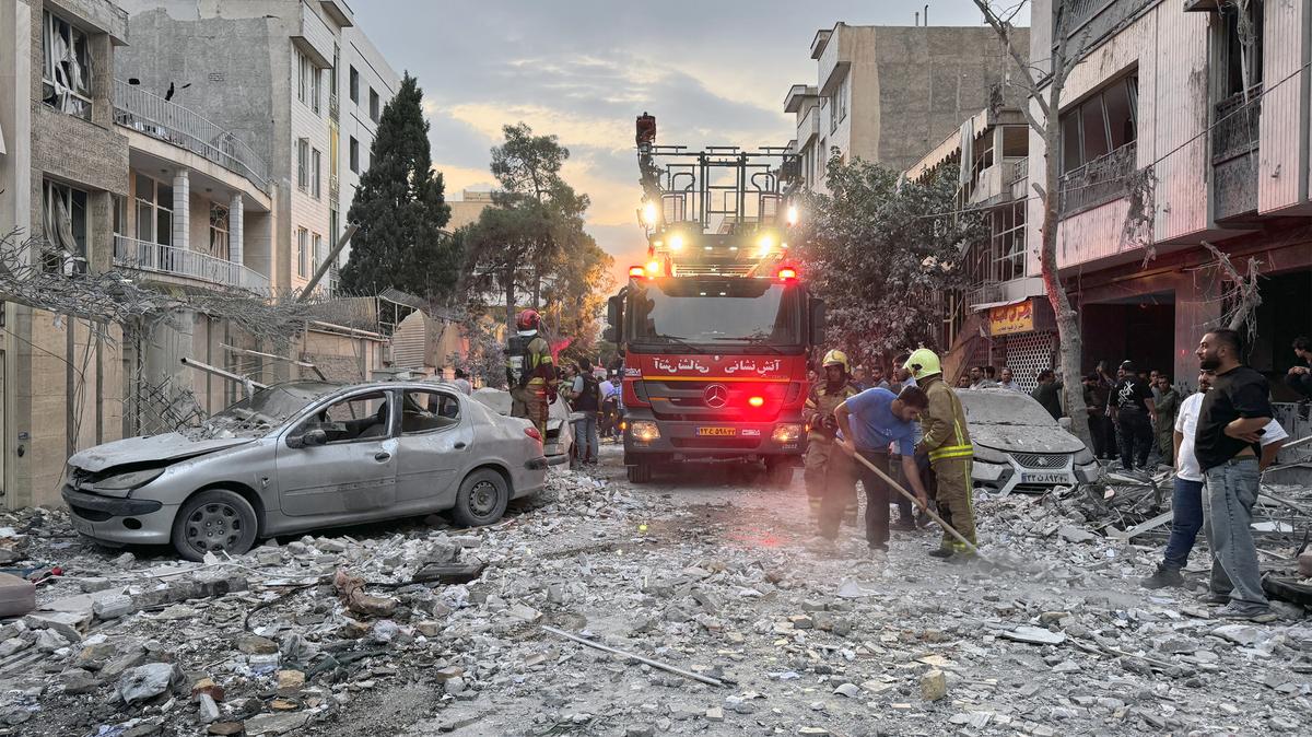 First-responders gather outside a building that was hit by an Israeli strike in Tehran on June 13, 2025. Israel hit about 100 targets in Iran on June 13, including nuclear facilities and military command centres and killing senior figures including the armed forces chief and top nuclear scientists. (Meghdad Madadi/Tasmin News/AFP/Getty Images/TNS)
