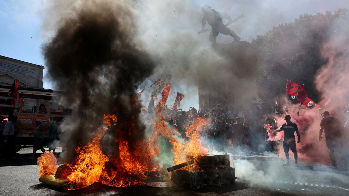 FILE PHOTO: A cardboard model of a bulldozer burns as demonstrators release colored smoke during a march against racism, war and exploitation and in support of migrants’ rights in Rome, Italy, June 13, 2026. REUTERS/Matteo Minnella/File Photo