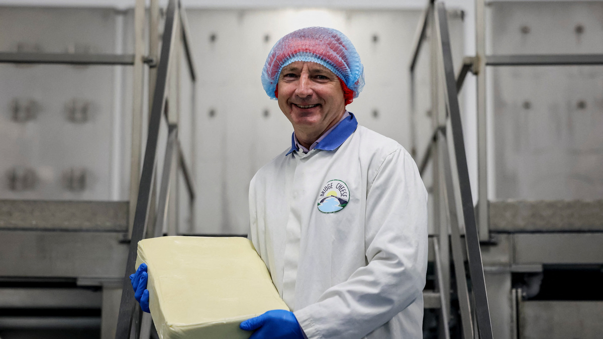 Michael Harte, managing director of Bridge Cheese, holds a block of cheese at the Bridge Cheese factory in Telford, Britain, June 10, 2026. REUTERS/Temilade Adelaja