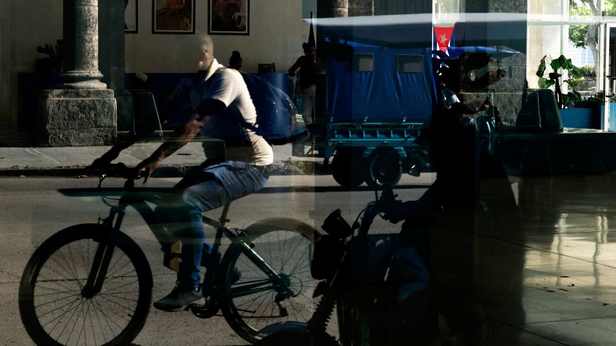People are reflected in a window of the Central Palace of Computing and Electronics bearing images of late Cuban President Fidel Castro and his brother, former President Raul Castro, who was indicted in the United States in a move that marks an escalation in Washington's pressure campaign against the Caribbean island's communist government, in Havana, Cuba May 20, 2026. REUTERS/Norlys Perez