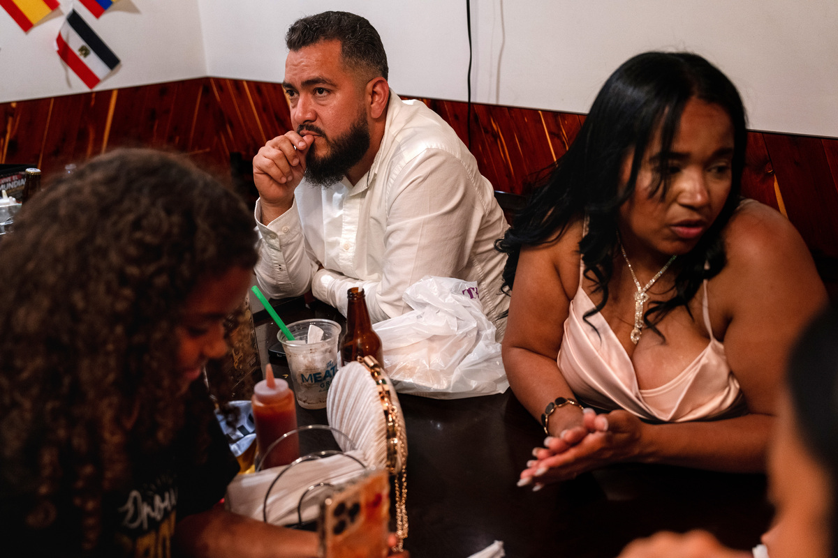 Yibran Espinoza, left, and Marian Galindez eat with their family and friends at El Budare Cafe in the Jackson Heights neighborhood of Queens, on Thursday, June 25, 2026. El Budare Cafe is one of the Venezuelan restaurants that are accepting donations to send supplies to Venezuela after two earthquakes struck on Wednesday. (Lexi Parra/The New York Times)