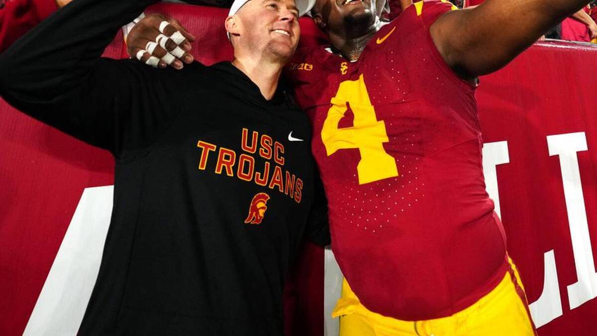  Nov 29, 2025; Los Angeles, California, USA; Southern California Trojans head coach Lincoln Riley (right) and defensive tackle Jahkeem Stewart (4) pose with fans after the game against the UCLA Bruins at United Airlines Field at Los Angeles Memorial Coliseum. Mandatory Credit: Kirby Lee-Imagn Images | Kirby Lee-Imagn Images 