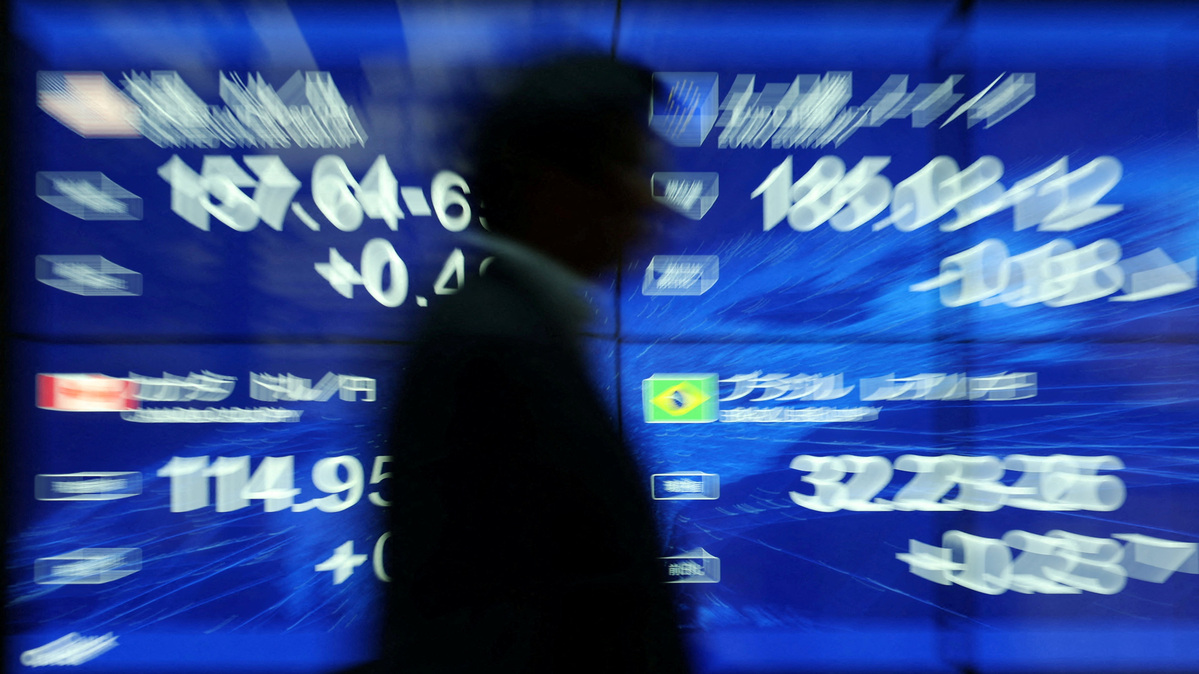 FILE PHOTO: A passersby walks past an electronic screen displaying the current Japanese Yen exchange rate against the U.S. dollar, Euro and other foreign currencies in Tokyo, Japan May 12, 2026. REUTERS/Issei Kato/File Photo