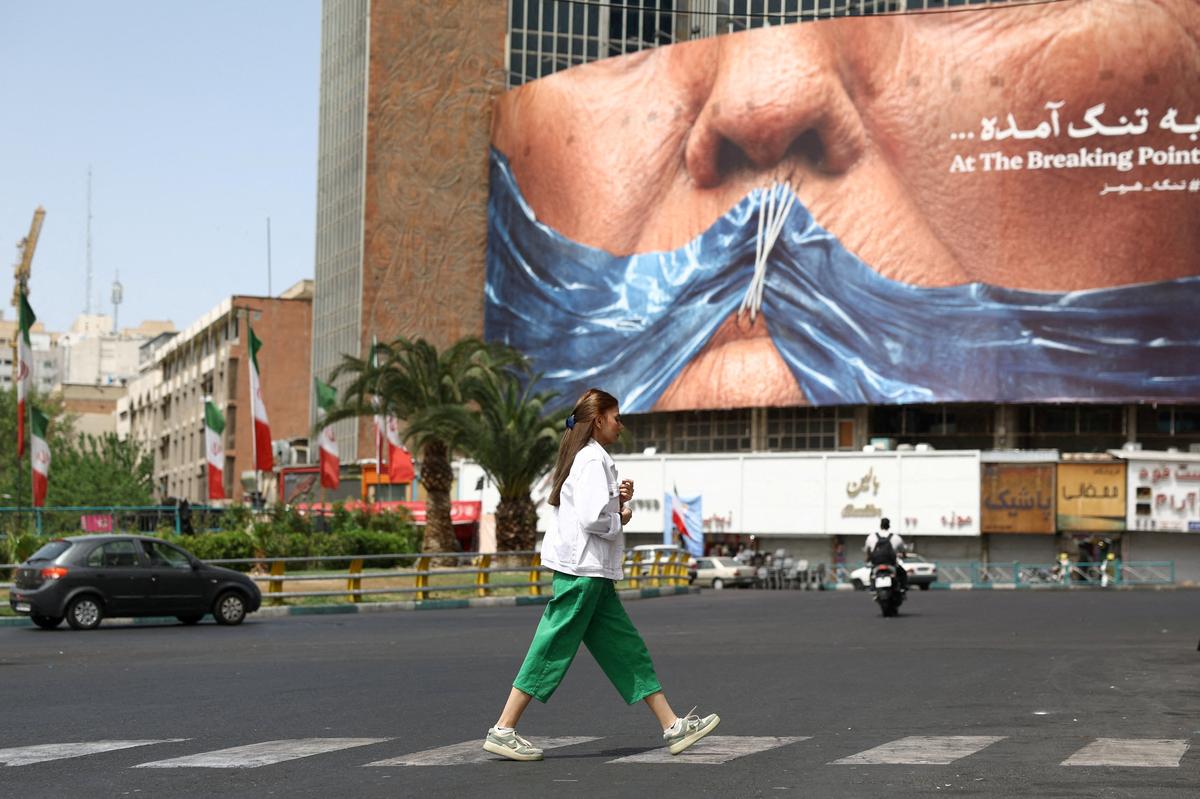 A woman walks past an anti-U.S. billboard depicting U.S. President Donald Trump and the Strait of Hormuz, in Tehran, Iran, May 8, 2026. Majid Asgaripour/WANA (West Asia News Agency) via REUTERS
