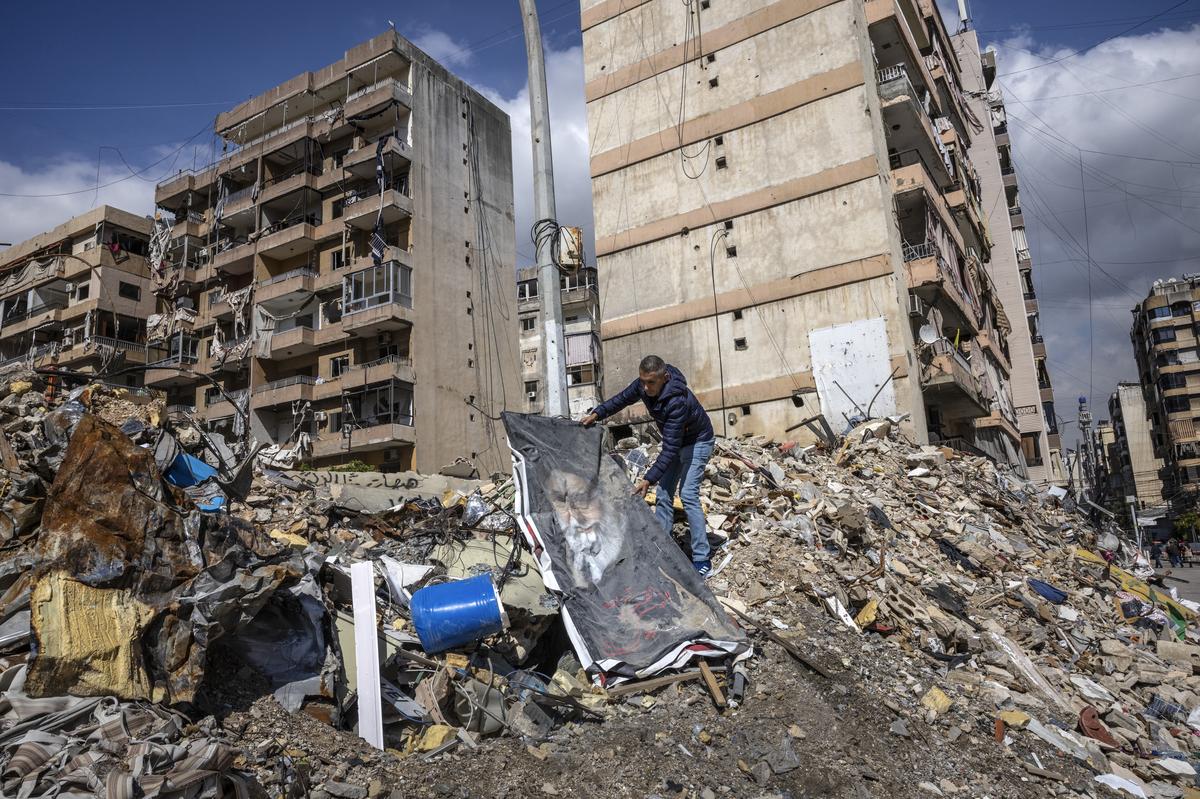 A man lays out a poster of Ayatollah Ali Khamenei, the late supreme leader of Iran, on a pile of rubble from Israeli airstrikes in Dahiyeh, a stronghold of Hezbollah and suburb of Beirut, on Wednesday, May 6, 2026. An Iranian official said his government was looking at an American plan to end the war, hours after President Trump threatened to resume strikes. Earlier Wednesday, another Iranian official dismissed a reported proposal as a "list of American wishes." (David Guttenfelder/The New York Times)