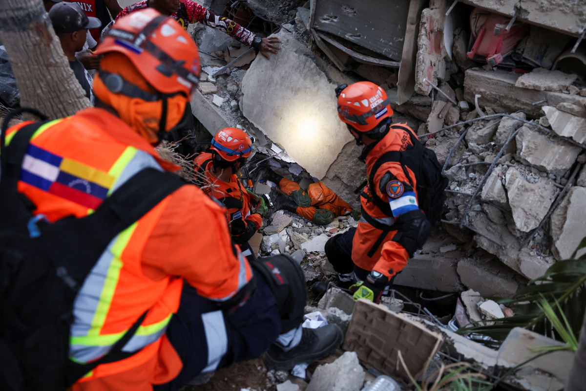 Members of the El Salvador rescue team search for survivors in the rubble of a collapsed building following an earthquake, in La Guaira, Venezuela, June 26, 2026. REUTERS/Leonardo Fernandez Viloria