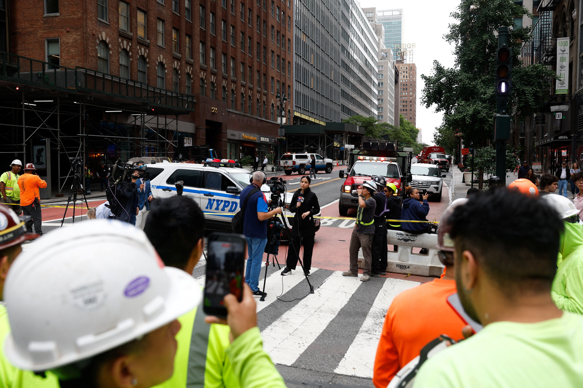 Members of the media work near a building on 42nd Street, which was reported to have structural issues, in New York City, U.S., July 7, 2026. REUTERS/Jordan Tovin