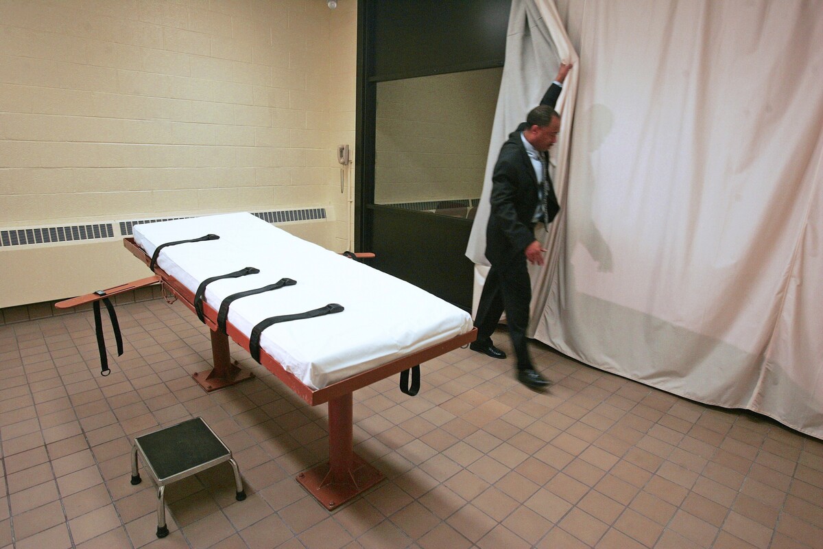  Larry Greene, public information director of the Southern Ohio Correctional Facility, demonstrates how a curtain is pulled between the death chamber and witness room at the prison in Lucasville, Ohio, in November 2005. (AP Photo/Kiichiro Sato, File) 