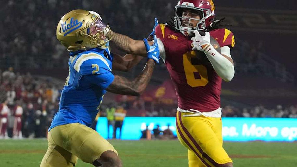  Nov 29, 2025; Los Angeles, California, USA; Southern California Trojans wide receiver Makai Lemon (6) carries the ball against UCLA Bruins defensive back Andre Jordan Jr. (2) in the second half at United Airlines Field at Los Angeles Memorial Coliseum. Mandatory Credit: Kirby Lee-Imagn Images | Kirby Lee-Imagn Images 