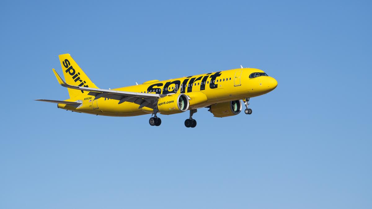 Spirit Airlines  airborne over Dallas Fort Worth International Airport. Spirit Airlines aircraft Airbus A320-271N airborne over Dallas Fort Worth International Airport (DFW), blue skies.