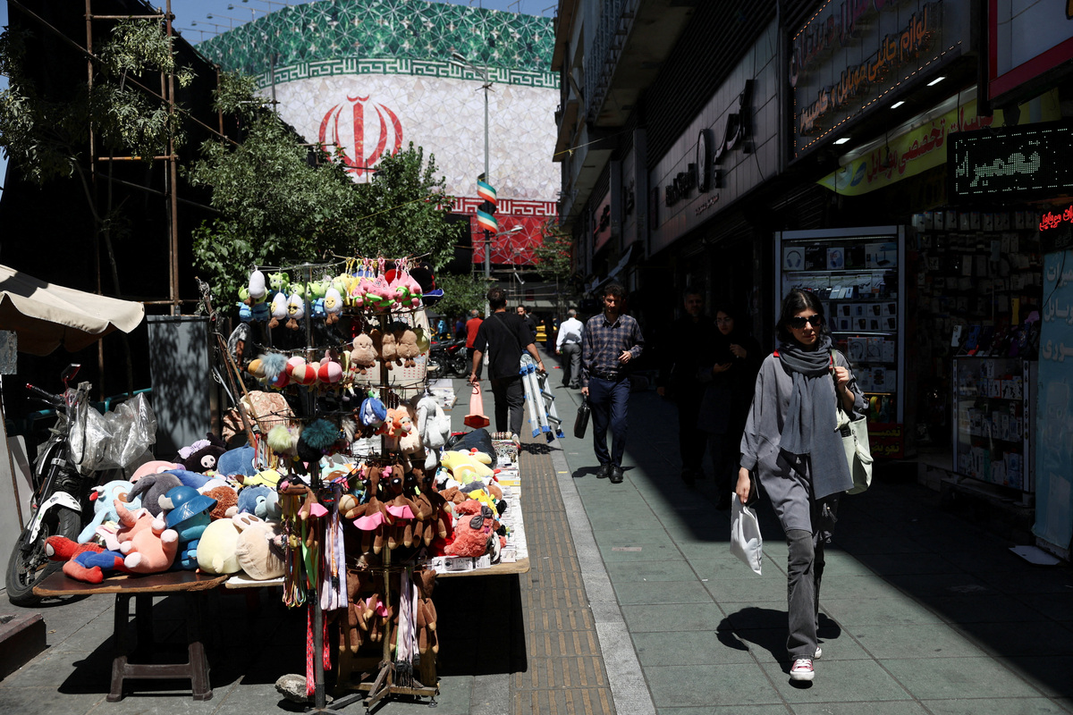 An Iranian woman walks on a street, after U.S. and Iranian officials said they had reached a deal to end their war and reopen the Strait of Hormuz, in Tehran, Iran, June 15, 2026. Majid Asgaripour/WANA (West Asia News Agency) via REUTERS