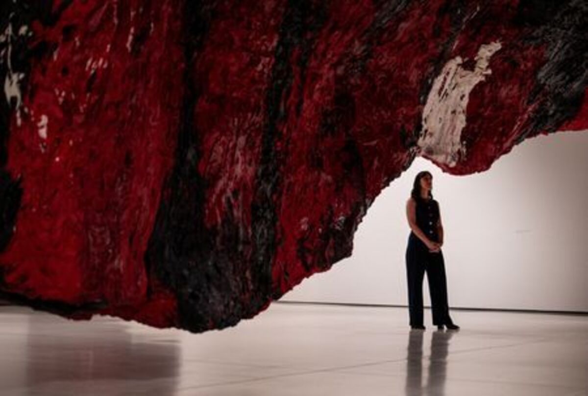 A gallery assistant poses for a photograph next to Anish Kapoor's installation 'Mount Moriah at the Gate of the Ghetto' (2022) during the press view for 'Anish Kapoor' at the Hayward Gallery, in London, Britain, June 15, 2026. REUTERS/Chris J. Ratcliffe