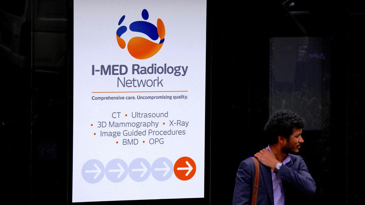 FILE PHOTO: A pedestrian stands next to a medical diagnostic imaging center for Australia's I-MED Radiology Network located in northern Sydney in Australia, November 21, 2017. Picture taken November 21, 2017.    REUTERS/David Gray/File Photo