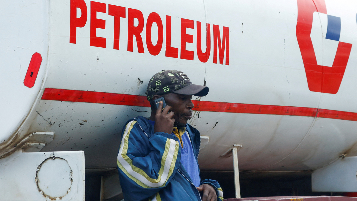 FILE PHOTO: A dealer talks on his mobile phone as fuel tankers queue outside the Kenya Pipeline Company (KPC) depot to re-fuel their commercial supplies, amid the U.S.-Israeli conflict with Iran, in the Industrial Area district of Nairobi, Kenya March 24, 2026. REUTERS/Thomas Mukoya/File Photo