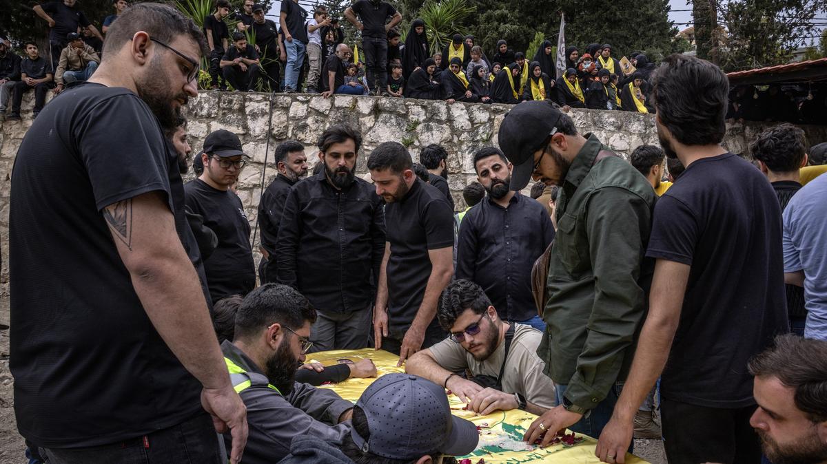 Coffins are brought to a cemetery during the funeral of several Hezbollah fighters and civilians, amid a temporary ceasefire between Lebanon and Israel, in the village of Maaroub, Lebanon, on Sunday. The Lebanese militant group declared on Monday that it would not lay down its weapons following the attack that left 14 people dead.
