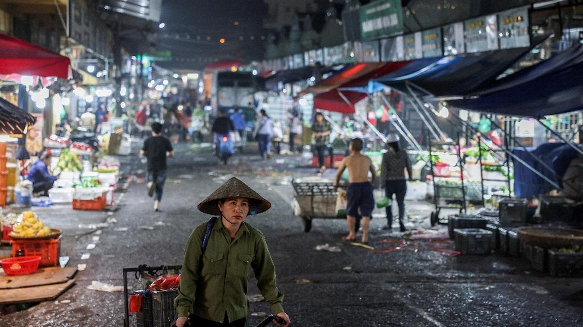 A merchant carries goods that she bought at Long Bien Market, one of the largest wholesale markets in Hanoi, in Hanoi, Vietnam, May 28, 2025. REUTERS/Chalinee Thirasupa