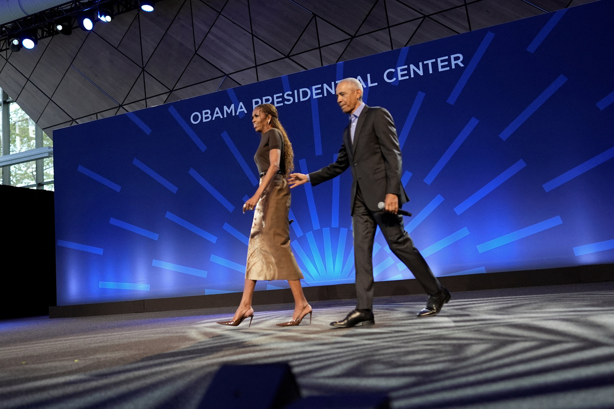 Former U.S. President Barack Obama and former U.S. first lady Michelle Obama walk out on stage to deliver remarks at a stakeholders event at the Obama Presidential Center in Chicago, Illinois, U.S., June 16, 2026. Pablo Martinez Monsivais/Pool via REUTERS