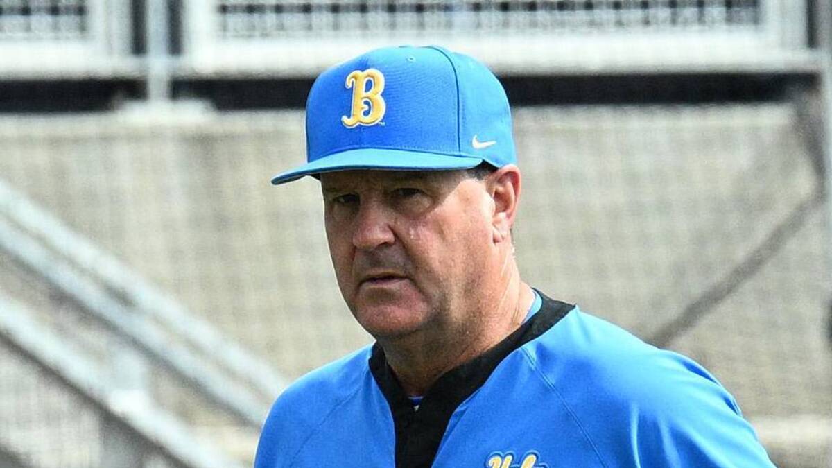  Jun 17, 2025; Omaha, Neb, USA; UCLA Bruins head coach John Savage (22) walks to the dugout before the restart of the game against the LSU Tigers at Charles Schwab Field. Mandatory Credit: Steven Branscombe-Imagn Images | Steven Branscombe-Imagn Images 
