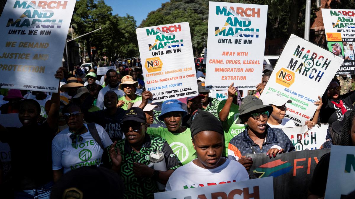 FILE PHOTO: Members of civil society groups and human rights organisations hold placards as they take part in a march calling for stronger government action against illegal immigration in Pretoria, South Africa, April 28, 2026. REUTERS/Ihsaan Haffejee/File Photo