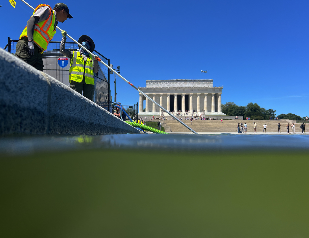  Cleaners use a vacuum pump to clean algae off the bottom of the Lincoln Memorial Reflecting Pool on June 16, 2026, in Washington, D.C. 