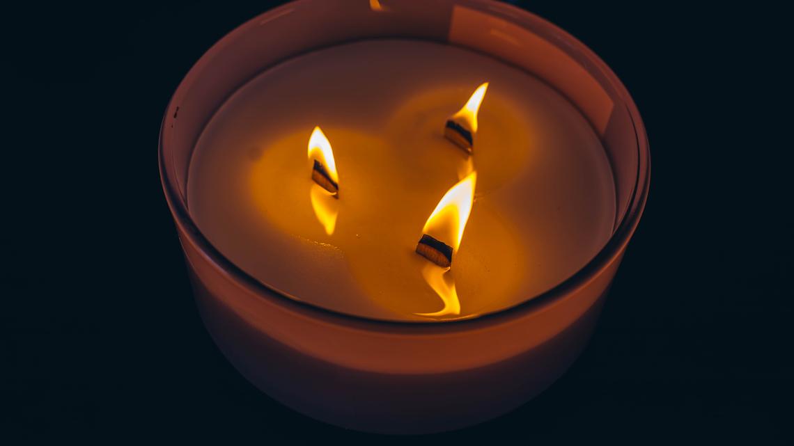 Three-wick candle symbolizing release and atmosphere of calm and serenity. High quality photo