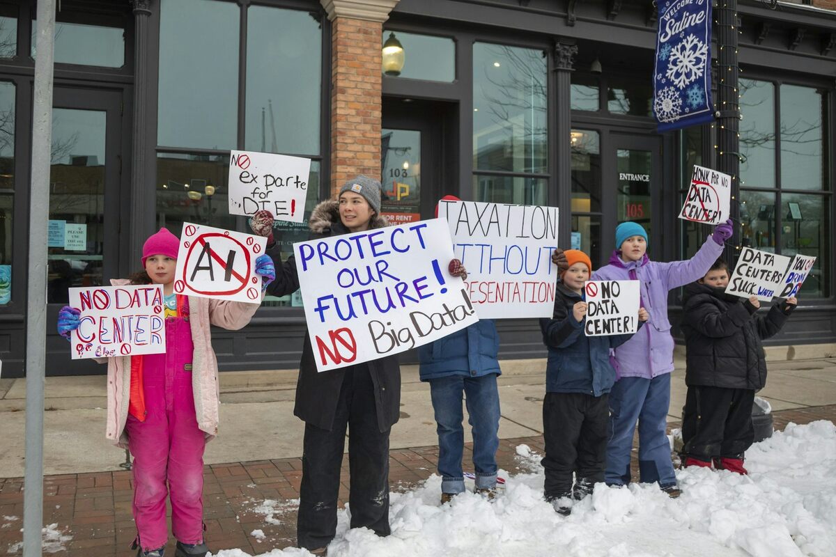  People in Saline, Mich., hold signs opposing a data center proposed in their community. Jim West/UCG/Universal Images Group via Getty Images 