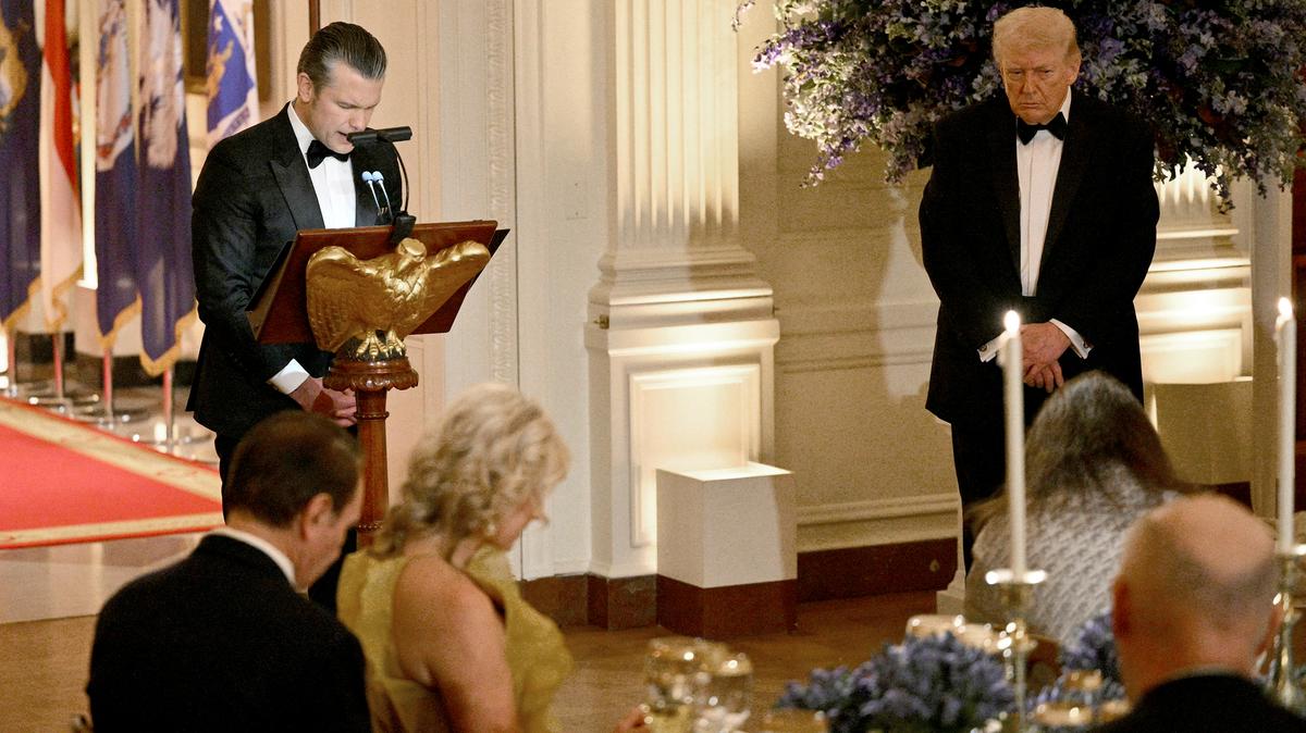 Defense Secretary Pete Hegseth (L) conducts a prayer as US President Donald Trump (R) listens during a dinner with state governors in the East Room of the White House in Washington, DC, on Feb. 21, 2026. (Mandel NGAN/AFP/Getty Images/TNS)