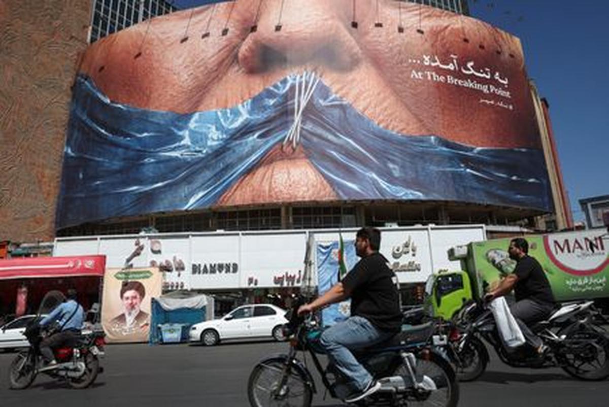 People ride past an anti-U.S. billboard depicting U.S. President Donald Trump and the Strait of Hormuz, in Tehran, Iran, May 25, 2026. Majid Asgaripour/WANA (West Asia News Agency) via REUTERS
