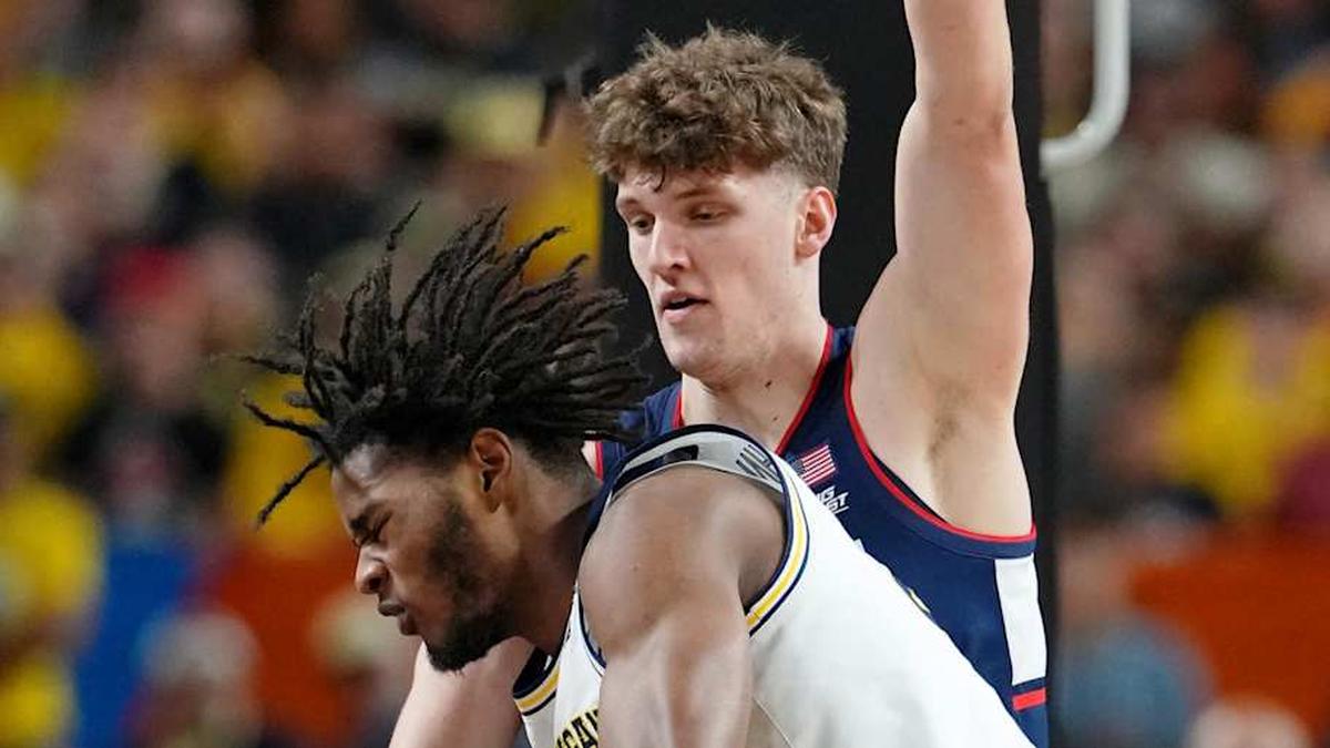  Apr 6, 2026; Indianapolis, IN, USA; Michigan Wolverines forward Morez Johnson Jr. (21) loses control of the ball against UConn Huskies center Eric Reibe (12) during the first half in the national championship of the Final Four of the men's 2026 NCAA Tournament between the and the Michigan Wolverines at Lucas Oil Stadium. Mandatory Credit: Bob Donnan-Imagn Images | Bob Donnan-Imagn Images 