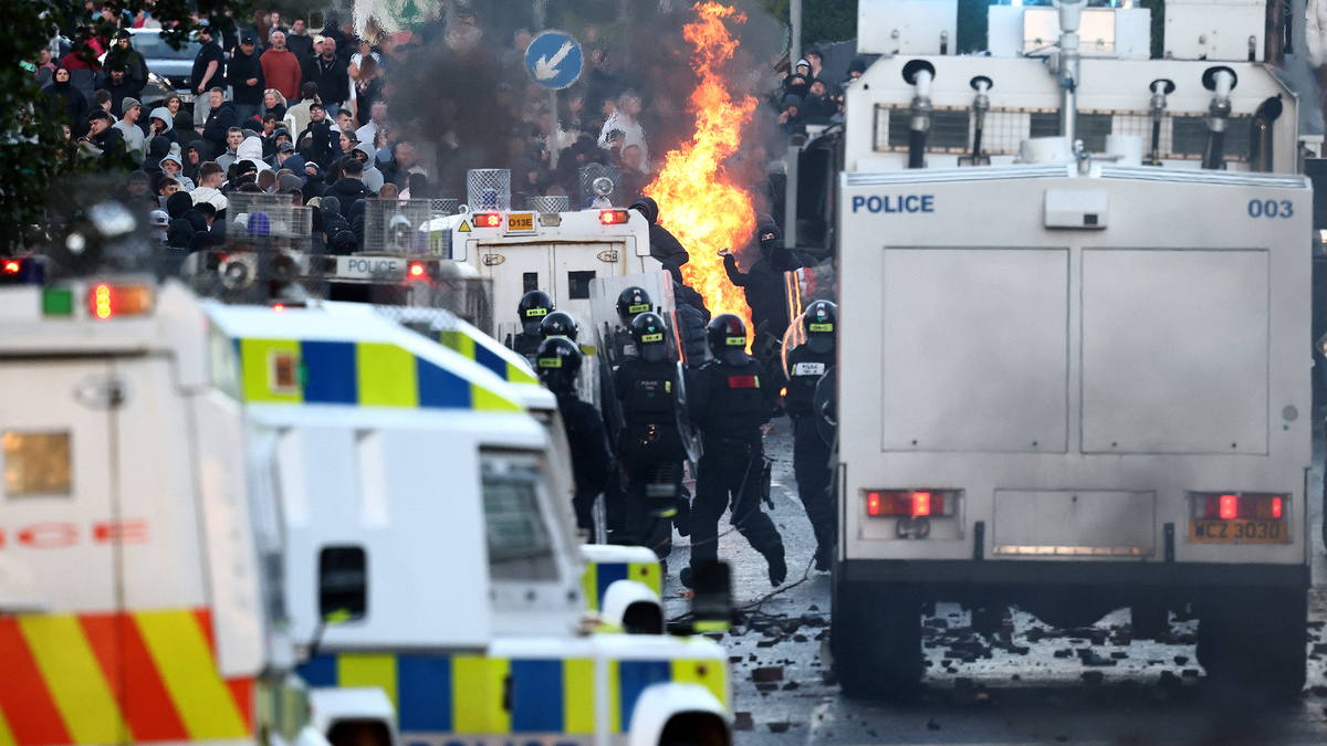 Protestors throw things at police blocking them from a road leading to a hotel previously believed to house migrants, in Glengormley, north of Belfast, Northern Ireland, on June 10, 2026. Police used a water cannon late on June 10 to disperse small crowds who had gathered for a second night in Northern Ireland as UK authorities blamed far-right activists for stoking anger on social media following a brutal stabbing. (Henry Nicholls/AFP via Getty Images/TNS)