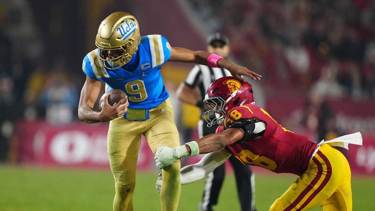  Nov 29, 2025; Los Angeles, California, USA; UCLA Bruins quarterback Nico Iamaleava (9) is tackled by Southern California Trojans linebacker Eric Gentry (18) in the second half at United Airlines Field at Los Angeles Memorial Coliseum. Mandatory Credit: Kirby Lee-Imagn Images | Kirby Lee-Imagn Images 