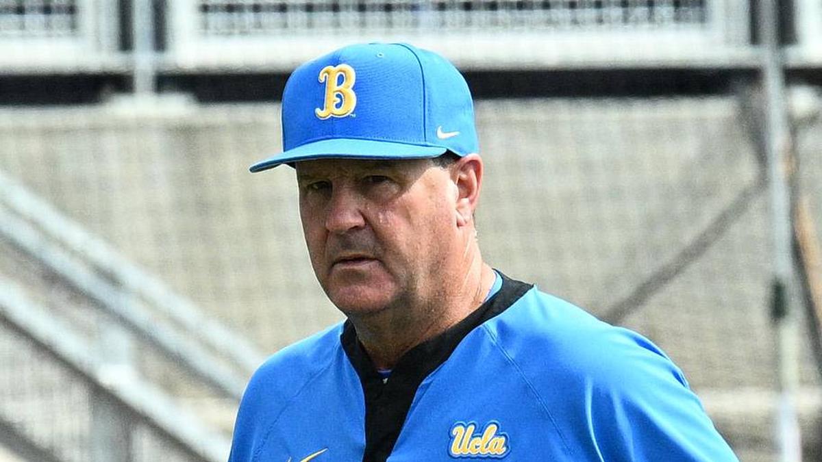  Jun 17, 2025; Omaha, Neb, USA; UCLA Bruins head coach John Savage (22) walks to the dugout before the restart of the game against the LSU Tigers at Charles Schwab Field. Mandatory Credit: Steven Branscombe-Imagn Images | Steven Branscombe-Imagn Images 