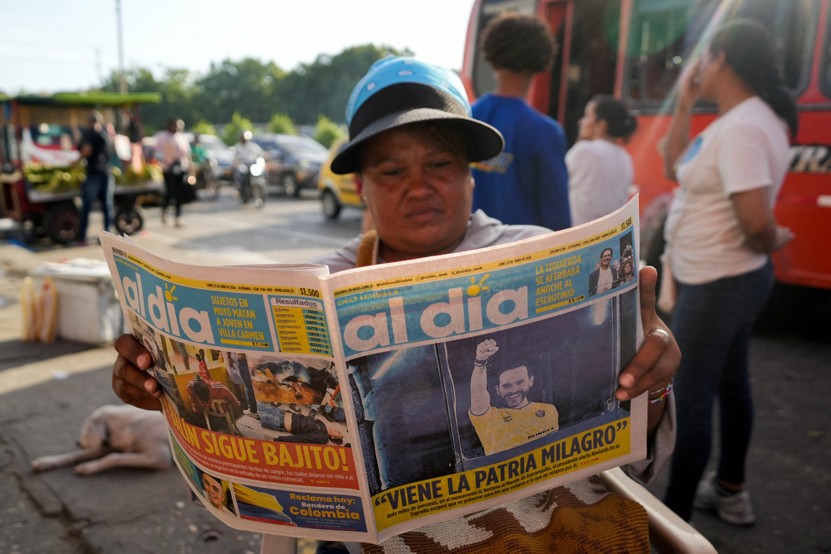 A woman reads a newspaper announcing that right-wing candidate Abelardo De La Espriella won the presidential race according to an initial ballot count, following the runoff against leftist candidate Ivan Cepeda, in Barranquilla, Colombia June 22, 2026. REUTERS/Charlie Cordero